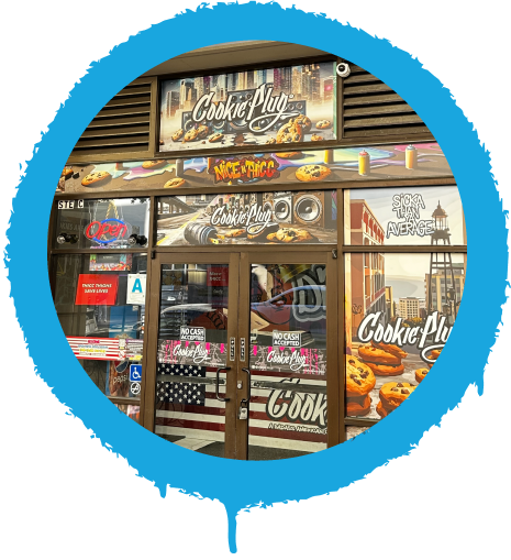 Fun and colorful storefront with a graffiti sign that says 'Cookie Plug' with large images of chocolate chip cookies in the window